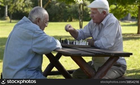 Active retired people, best friends and leisure, group of old men having fun and playing chess game at park. Sequence of wide and medium shot