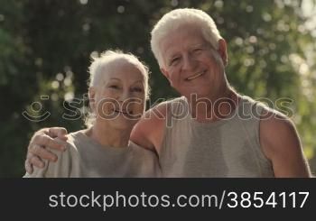 Active retired people, portrait of happy senior husband and wife after fitness and jogging in city park