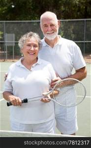 Active senior couple on the tennis courts.