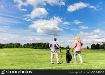 Active senior couple playing golf in the summer. Retirement activity.. Active senior couple playing golf on a course.