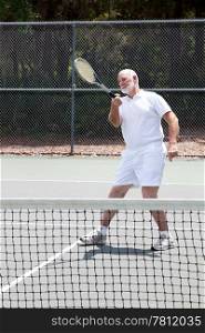 Active senior man playing a game of tennis.