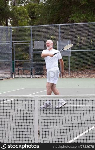 Active senior man plays tennis for exercise and fun.