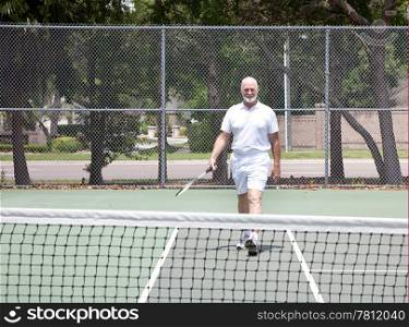 Active senior man stays fit on the tennis court.