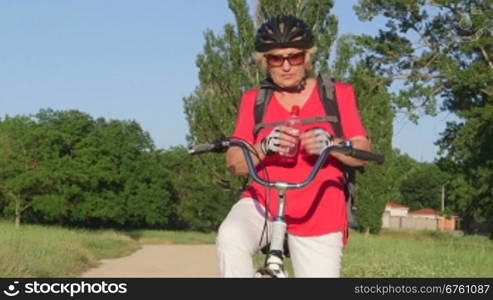 Active senior woman cyclist on bicycle during cycling