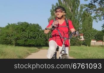 Active senior woman cyclist riding bicycle