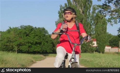 Active senior woman cyclist riding bicycle