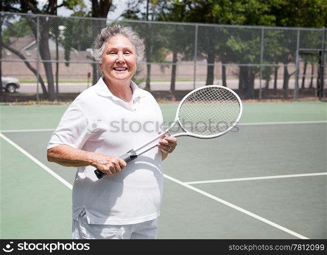 Active senior woman on the tennis courts.