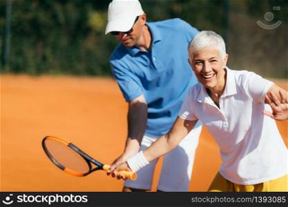 Active Senior Woman Practicing Tennis