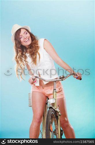 Active smiling woman riding bike bicycle. Young girl in hat, white shirt and shorts. Healthy lifestyle and recreation leisure activity. Studio shot.. Active woman riding bike bicycle. Recreation.