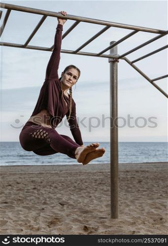 active woman doing fitness exercises outdoors by beach