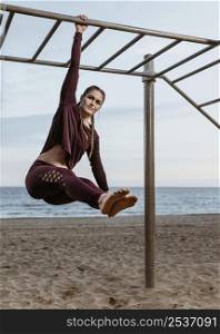 active woman doing fitness exercises outdoors by beach