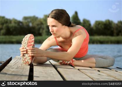 Active woman doing stretching exercise outdoors