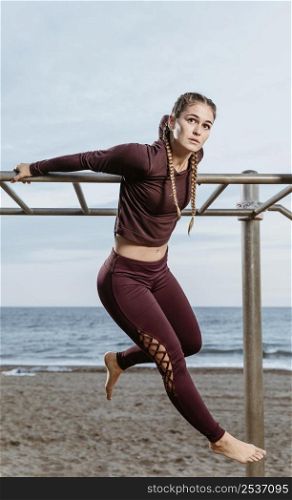 active woman exercising outdoors by beach