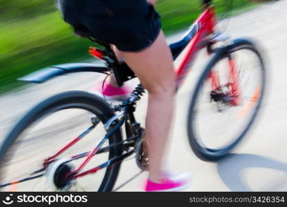 Active woman on a bike trip during summer. Lens blur