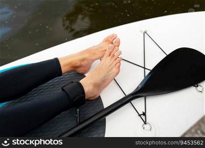 Active woman on surfboard, closeup of water surface, legs and board. Outdoor activity. Active woman on surfboard, closeup of water surface, legs and board. Outdoor activity.