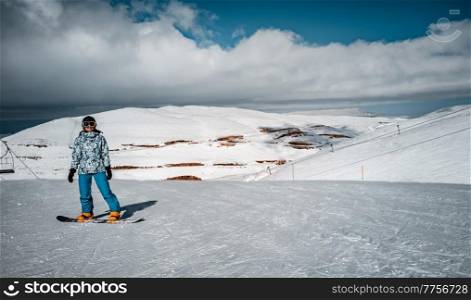 Active Woman Standing on Snowboard in High Snowy Mountains. Spending Winter Vacation on Ski Resort. Happy Sportive Lifestyle.. Happy Woman on Snowboard