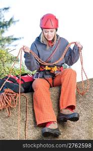 Active young woman prepare for rock climbing holding rope