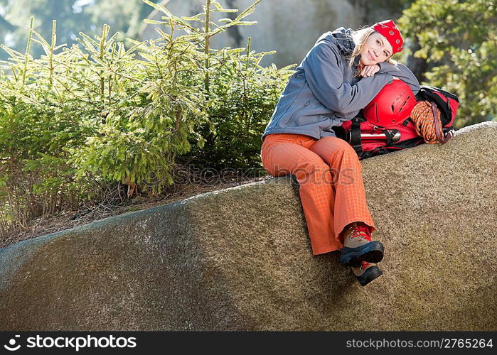 Active young woman rock climbing relax on backpack in mountains