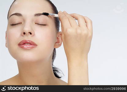 &acute;Young woman brushing eyebrows,close-up&acute;