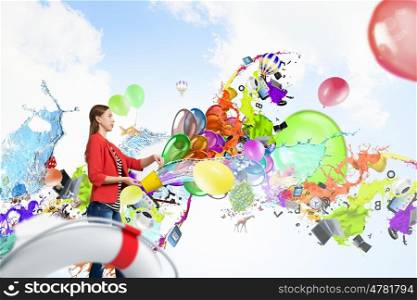 Add color and holiday to your life. Young pretty woman with yellow bucket in hands and colorful balloons flying out