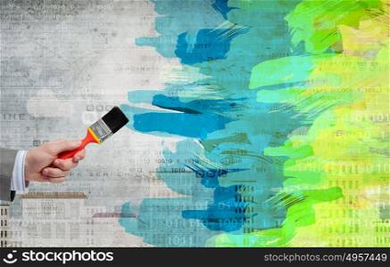 Add some color!. Close up of businessman hand painting wall in color