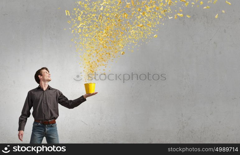 Add some color to your life!. Young man in casual splashing characters from bucket