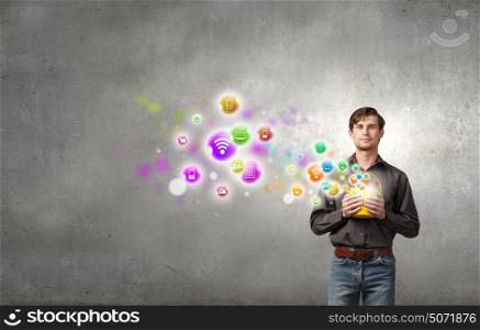 Add some color to your life!. Young man in casual splashing icons from bucket