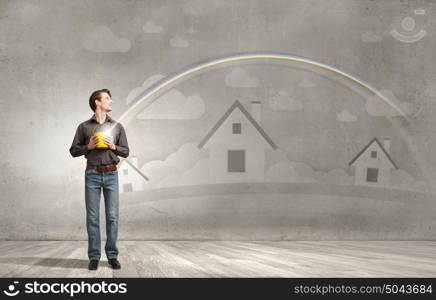 Add some color to your life!. Young man in casual splashing rainbow from bucket