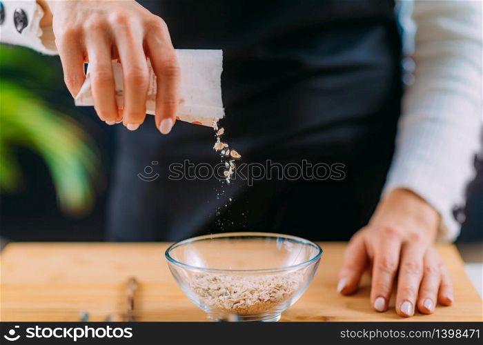 Adding oats into the bowl to make oatmeal