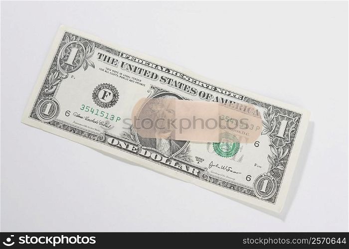 Adhesive bandage on a US dollar bill