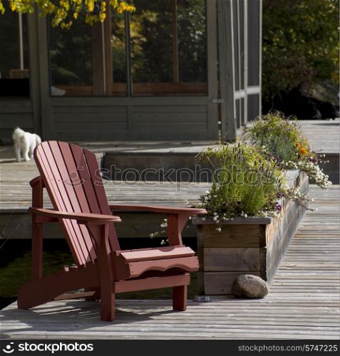Adirondack chair and planter on a dock, Lake of The Woods, Ontario, Canada