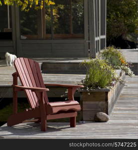 Adirondack chair and planter on a dock, Lake of The Woods, Ontario, Canada