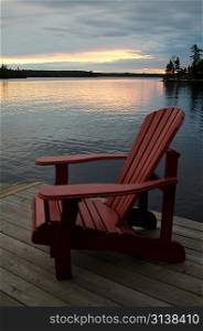 Adirondack chair on a pier at the lakeside, Lake of the Woods, Ontario, Canada