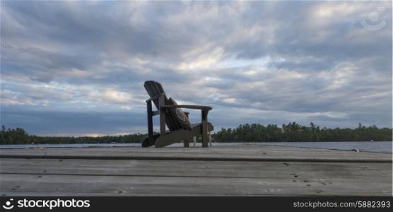 Adirondack chair on dock at lake, Lake Of The Woods, Ontario, Canada