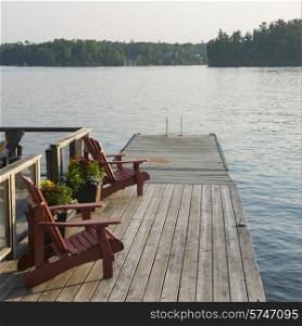 Adirondack chairs on a dock at the lakeside, Lake of The Woods, Ontario, Canada