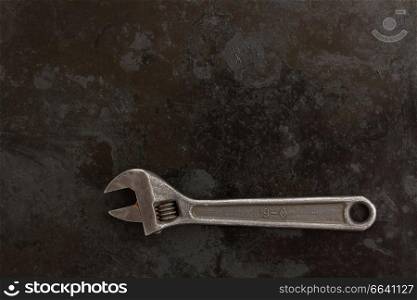 Adjustable spanner  on black metal background with copy space