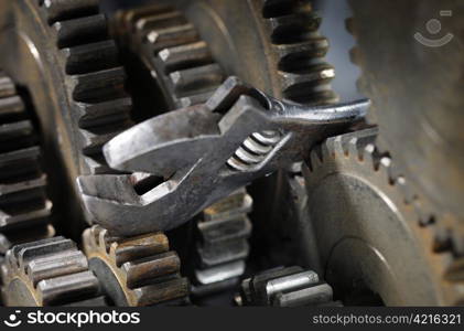 Adjustble wrench stuck between cog gear wheels.