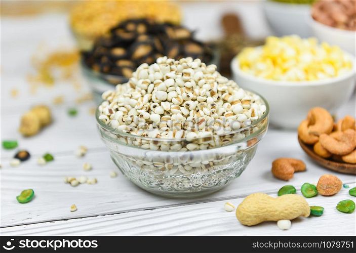 Adlay millet or pearl millet white Job&rsquo;s tears on bowl / Coix Lachrymal adlay jobi with different whole grains beans and legumes seeds background