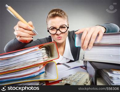 Administration workaholism clerk corporation concept. Crazy woman in office. Young angry lady at desk doing paperwork.. Crazy woman in office.
