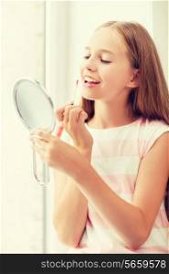 adolescence, beauty, makeup, happy people concept - teenage girl with lip gloss and mirror