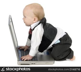 Adorable 10 month old baby boy in suit, barefoot, with laptop computer. Making cute grumpy face at computer screen.