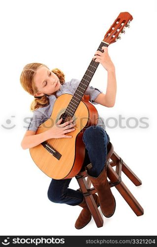 Adorable 7 year old blond girl playing acoustic guitar over white background.