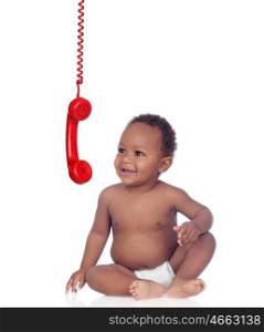 Adorable african baby looking a red telephone hunging isolated on a white background