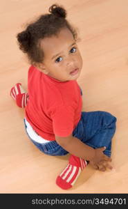 Adorable african baby sit over wooden floor