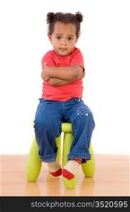 Adorable african baby sitting on green stool on a over white background