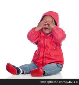 Adorable african baby sitting on the floor with red raincoat covering the face isolated on a white background