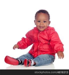 Adorable african baby sitting on the floor with red raincoat isolated on a white background