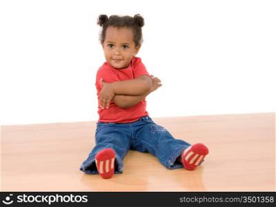 Adorable african baby sitting on wooden floor isolated over white