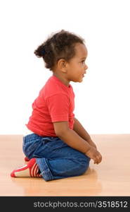 Adorable african baby sitting over wooden floor