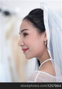 Adorable asian bride in white bride gown and bride veil with pearl necklace.